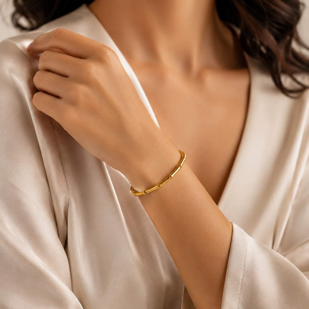 Gold bamboo-style anti-tarnish bracelet on woman's wrist, elegant everyday luxury jewelry