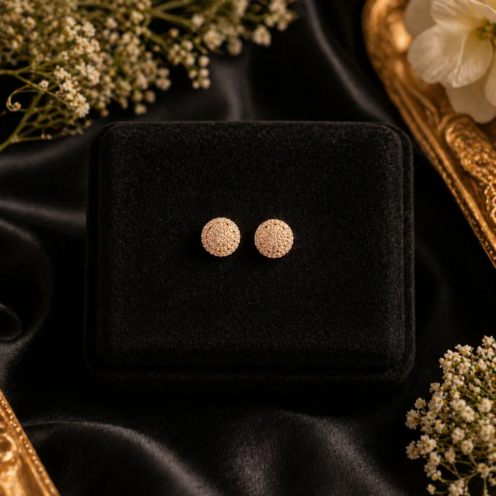 Sparkling gold stud earrings with cubic zirconia on black velvet, perfect for everyday luxury