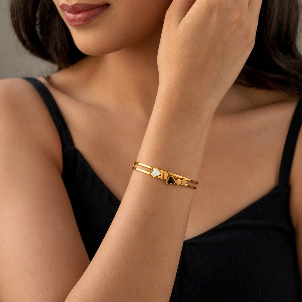 Gold heart charm bracelet with black and white accents, elegant everyday luxury jewelry for women
