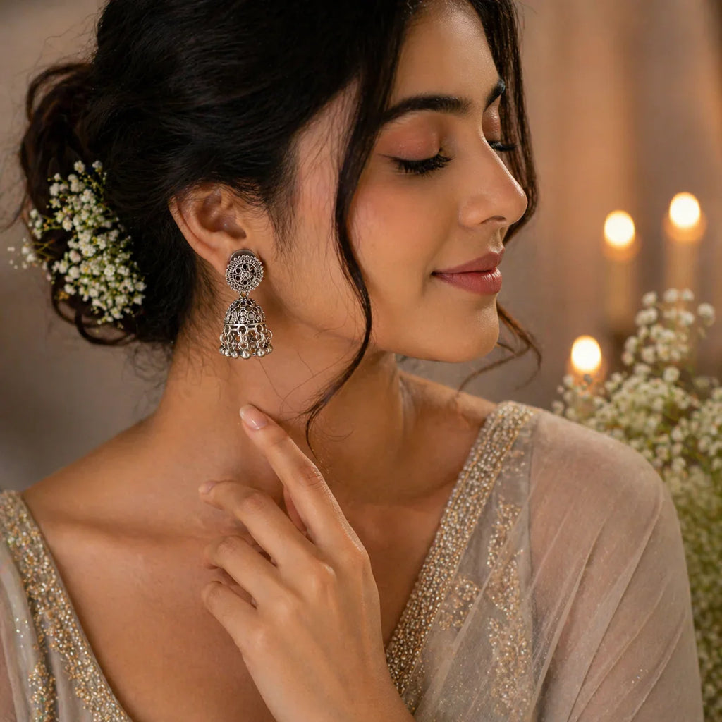 Elegant silver jhumka earrings with intricate filigree design, perfect for bridal or festive wear.
