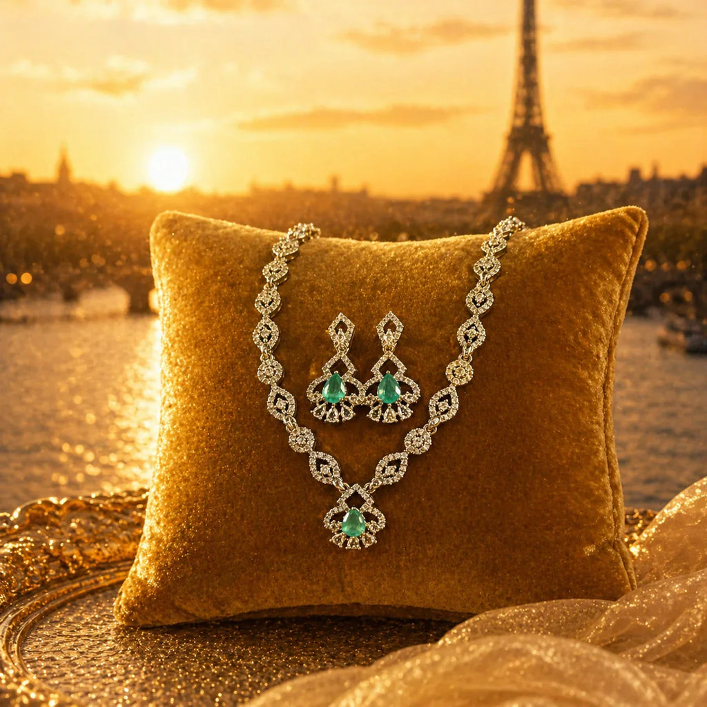 Emerald and diamond necklace & earrings set on gold pillow with Paris sunset backdrop