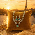 Emerald and diamond necklace & earrings set on gold pillow with Paris sunset backdrop