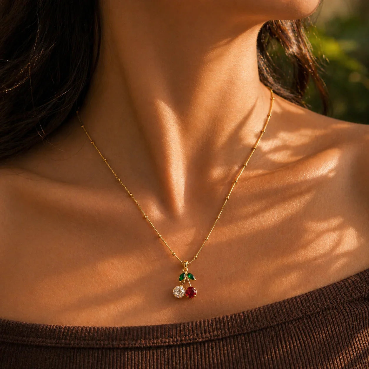 Gold cherry pendant necklace with red & clear gemstones, elegant women's jewelry for everyday wear
