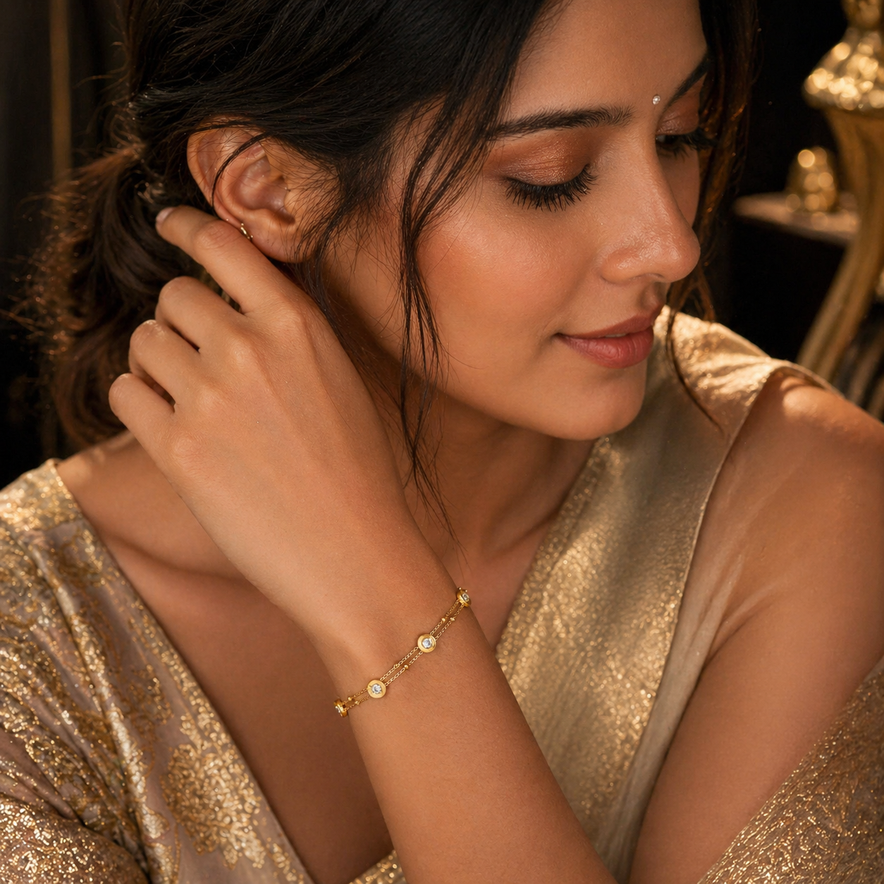 Elegant gold bracelet with diamond accents, worn by woman in golden attire, anti-tarnish luxury jewelry