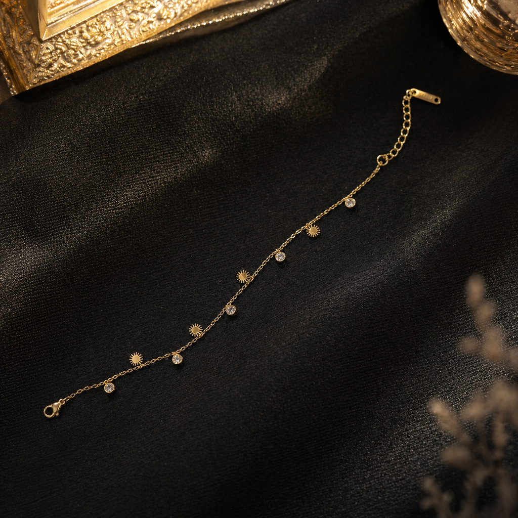 Gold sunburst charm bracelet with clear crystals on black fabric, elegant anti-tarnish jewelry for women